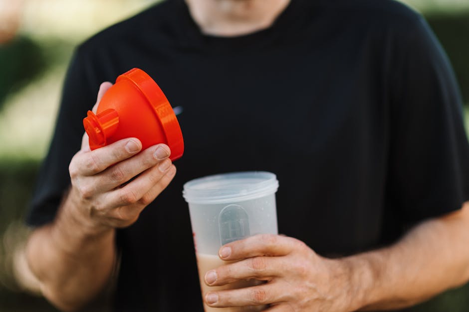 Protein shake and plate with protein-rich food — distributing protein across four meals works better than two large ones